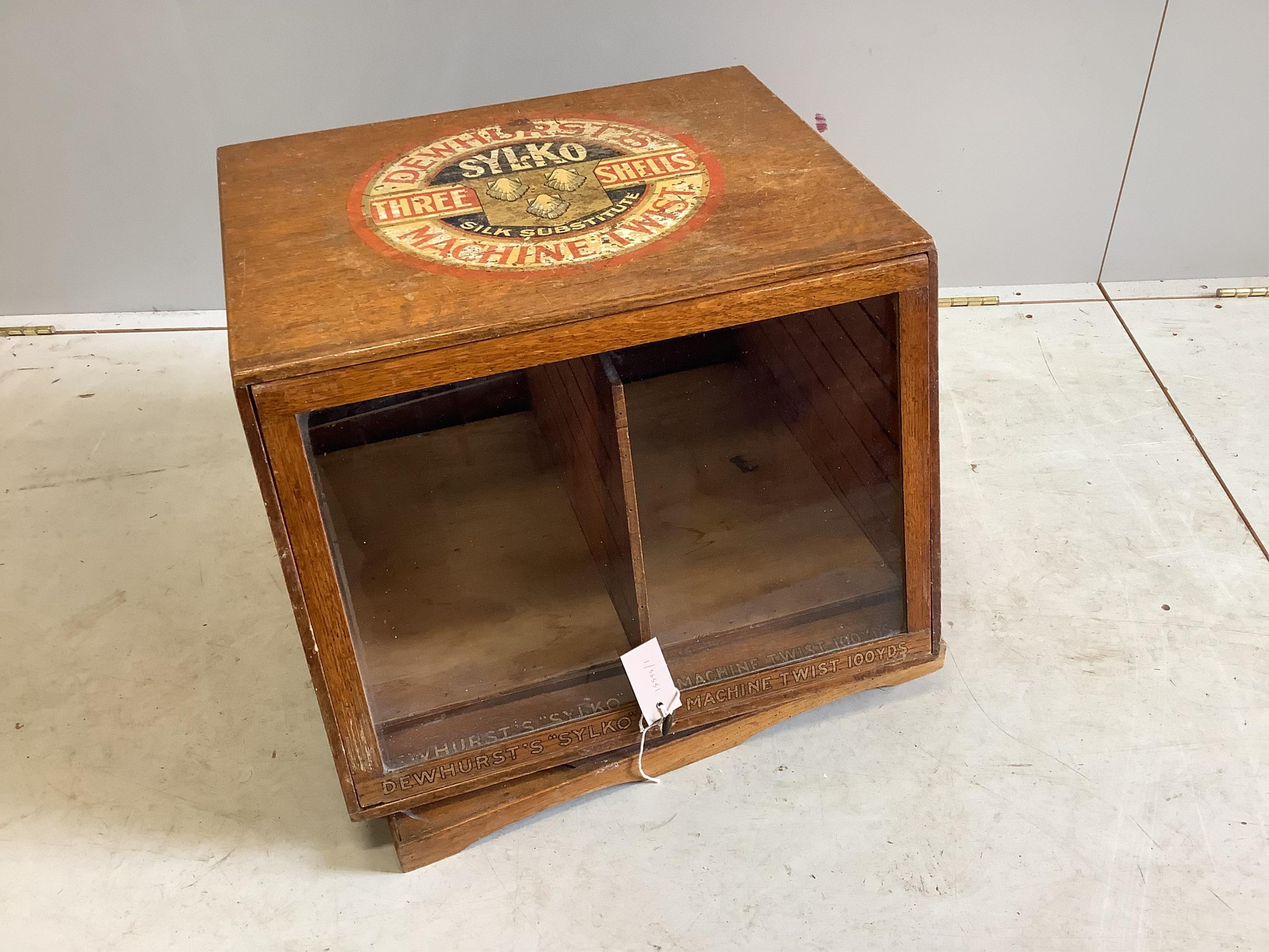 An early 20th century oak counter top display case, “Dewhurst’s Sylko Three Shells Machine Twist”, on swivel base, width 54cm, depth 52cm, height 42cm. Condition - fair